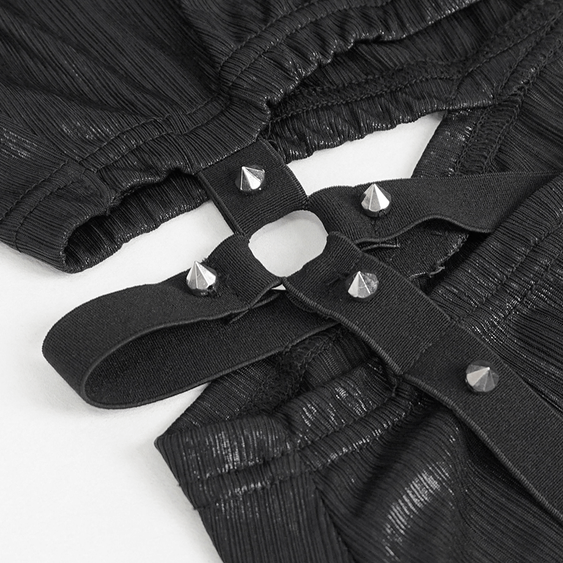 Close-up of black gothic dress detailing with stylish straps and metallic studs for a edgy fashion look.