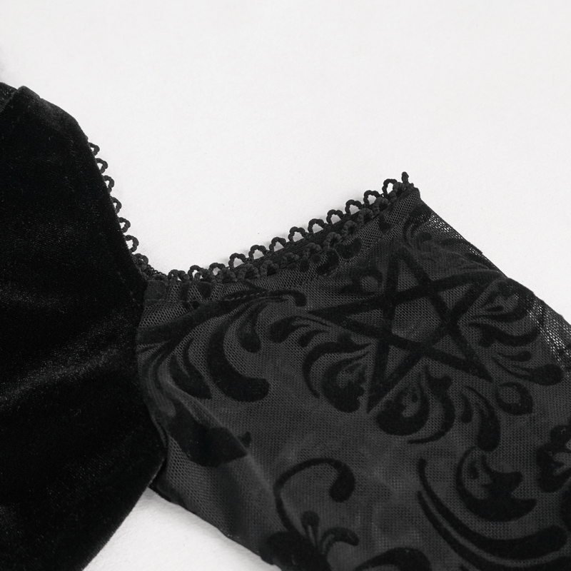 Close-up of a black velvet women's top showcasing intricate pattern and open shoulder design.
