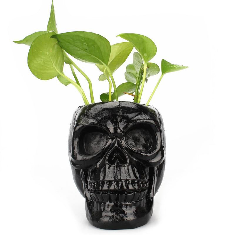 Black skull pen holder with green plants, perfect for Halloween decor and office storage.