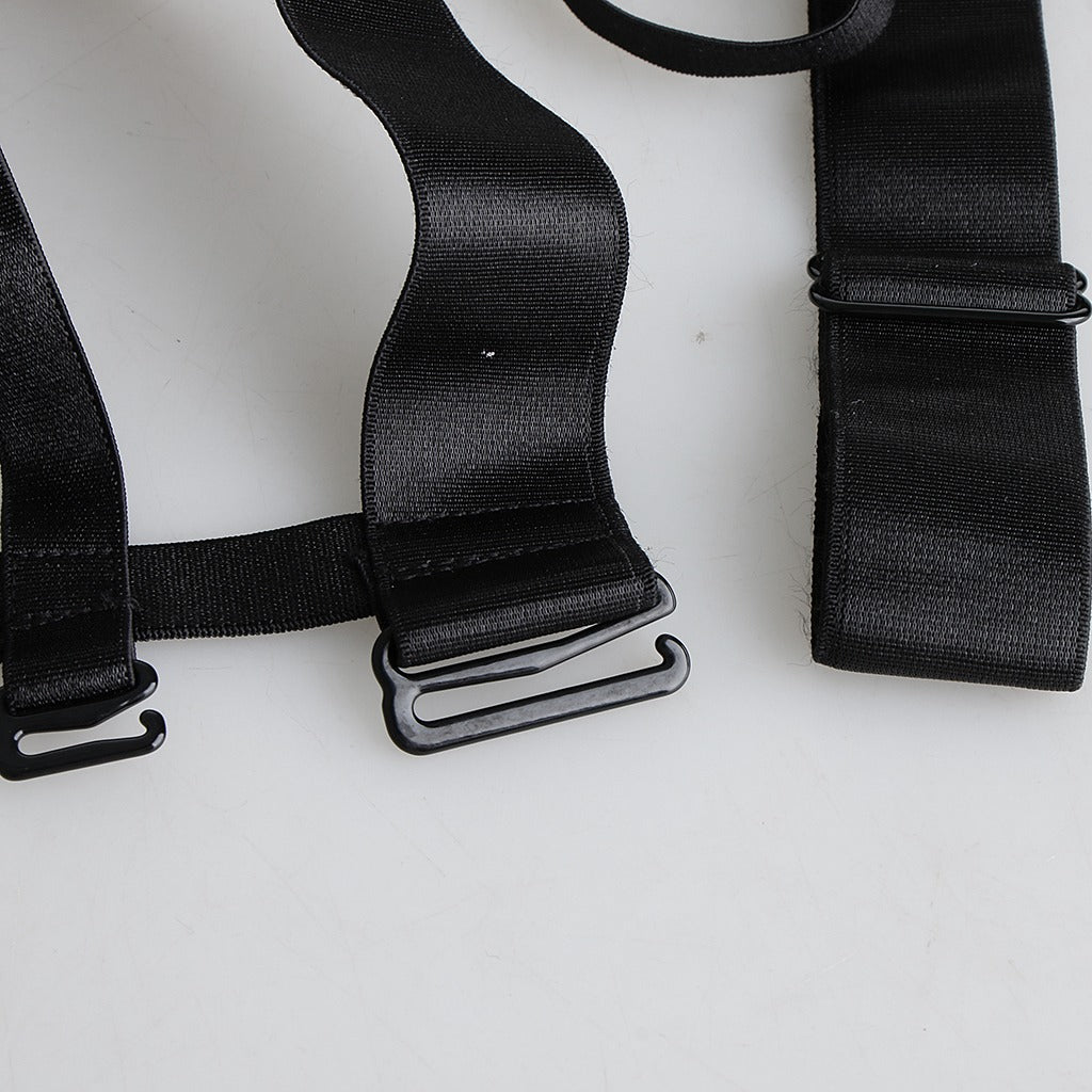 Close-up of black strappy nylon harness with metal clips, perfect for gothic-inspired outfits and accessories.