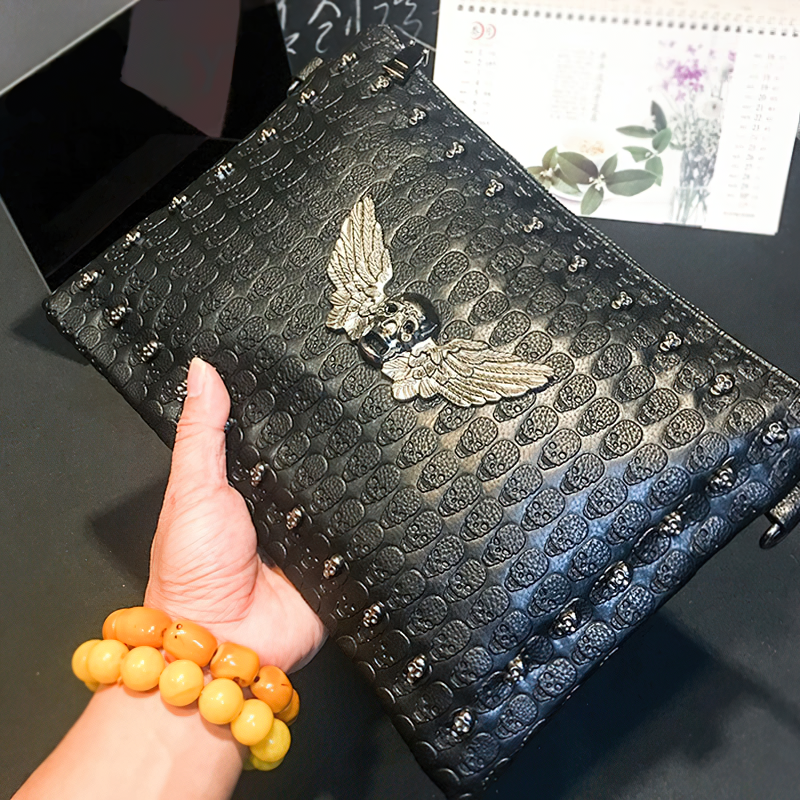 Stylish black unisex shoulder bag with winged skull design, perfect for alternative fashion lovers.