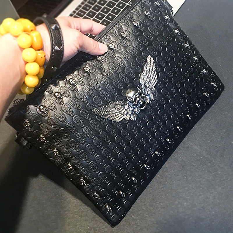 Black unisex shoulder bag with decorated skull and wings, perfect for concerts and alternative fashion.