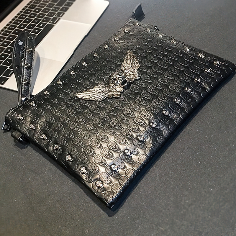 Black unisex shoulder bag with skull design and wing embellishment, perfect for alternative fashion lovers.