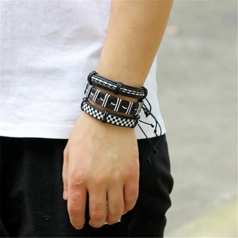 Stylish black and white leather bracelet set worn on wrist, showcasing rock-inspired braided design and charm details.