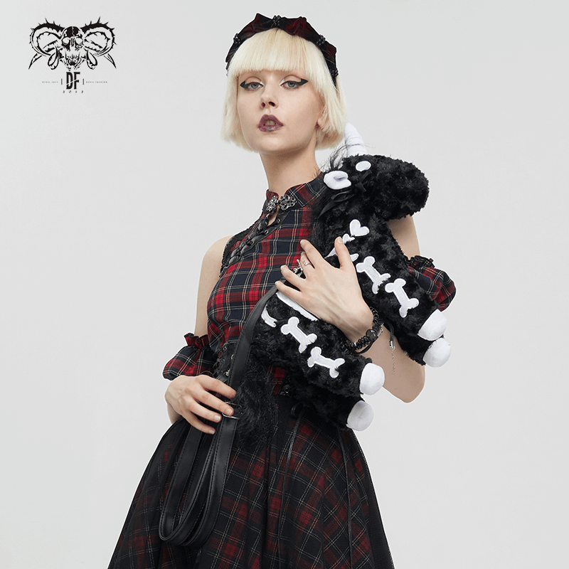 Chic woman holding a black plush unicorn handbag with white bones pattern, showcasing gothic fashion style.