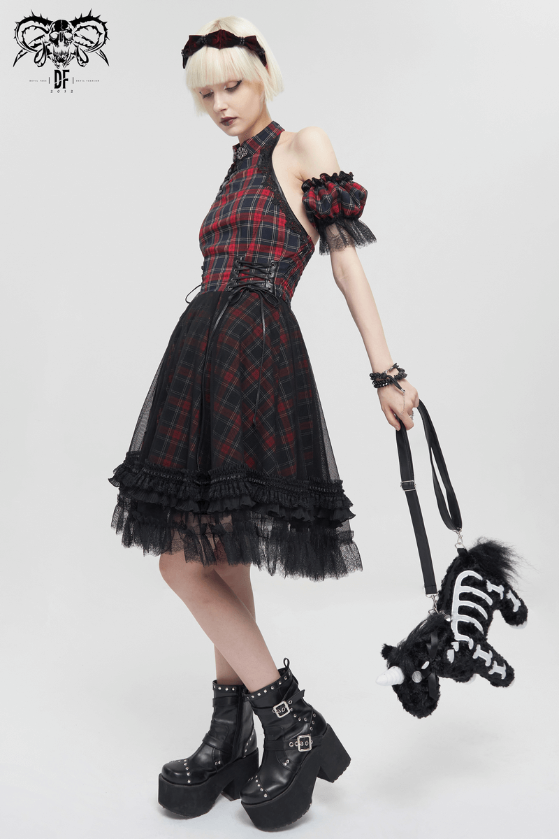 Fashionable Gothic dress with plaid pattern, model holds a plush toy and wears bold platform boots.