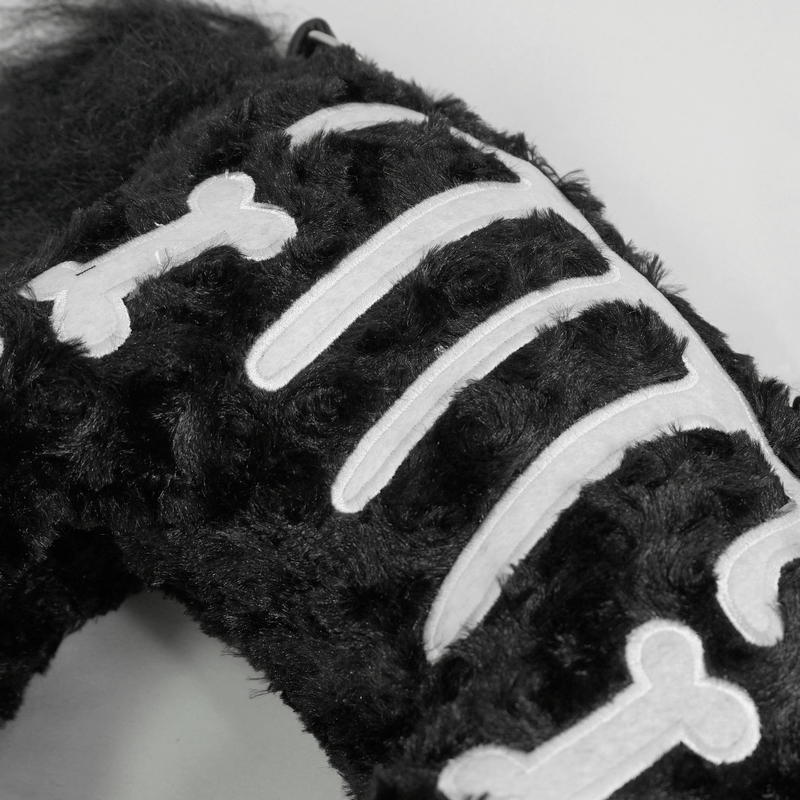 Close-up of black plush handbag featuring white bone pattern, perfect for gothic fashion lovers.