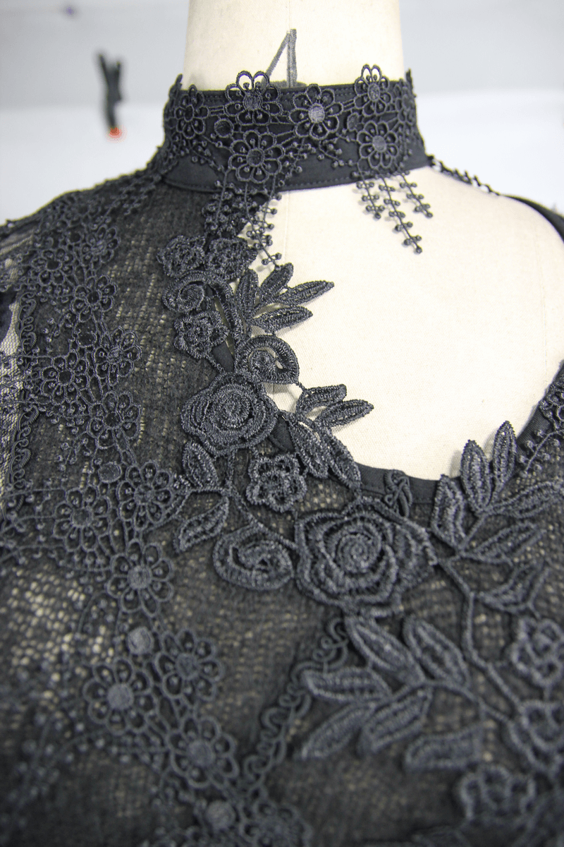 Close-up of a black lace top featuring intricate floral embroidery and an elegant asymmetrical design.