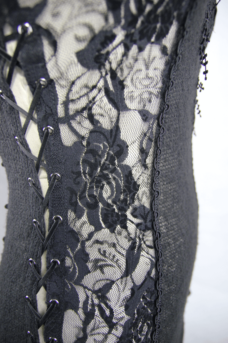 Close-up of black lace detailing with floral patterns and lacing on a gothic style women's top.