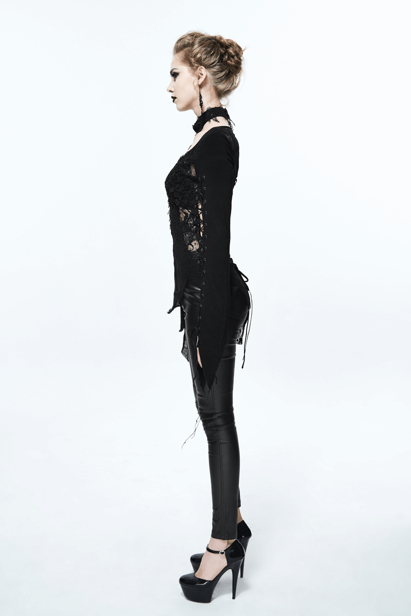 Side view of a woman in a black lace gothic asymmetric top paired with shiny leggings and high heels.