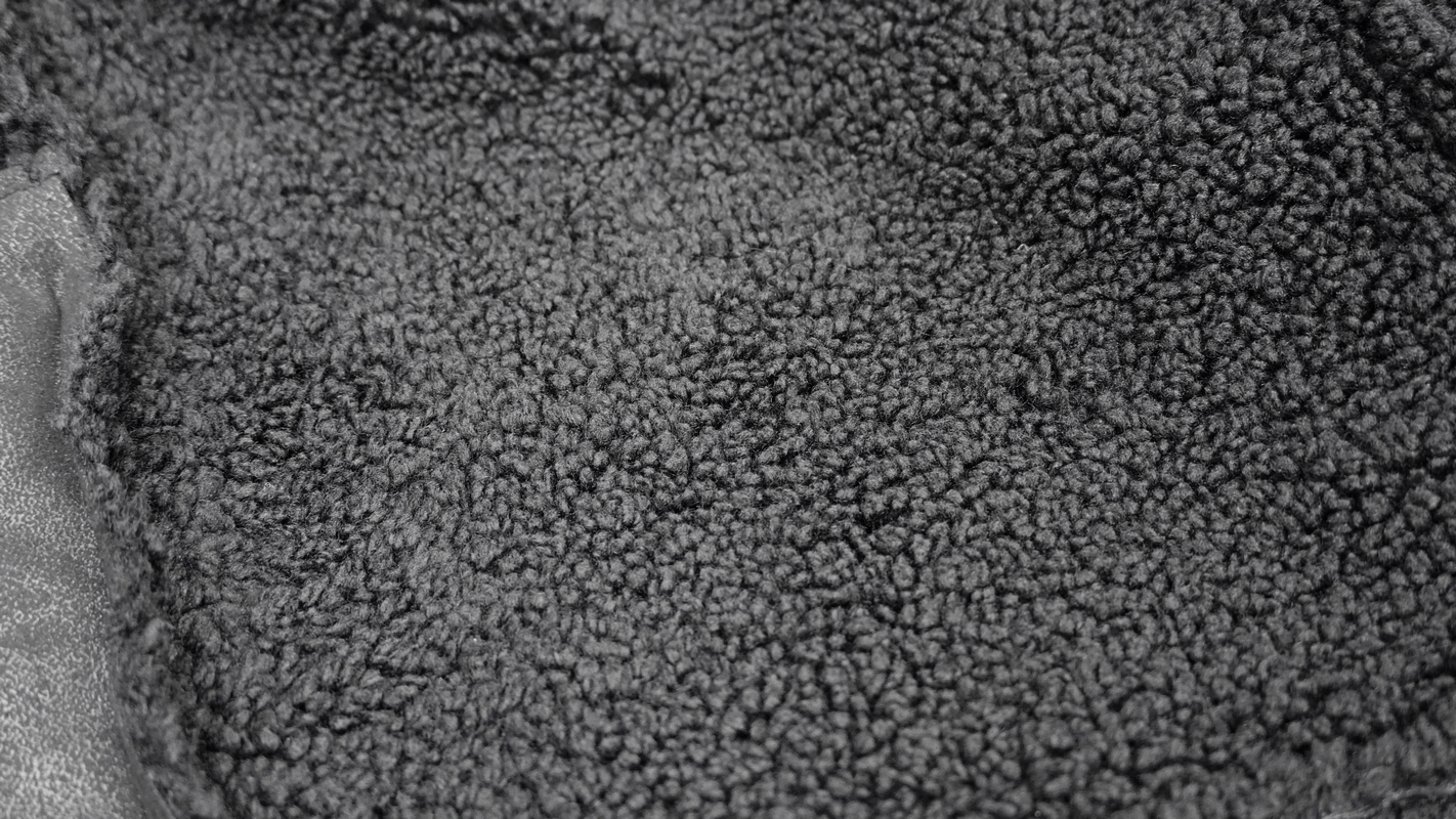 Close-up of soft, textured black fabric ideal for lining in jackets or cozy wear.
