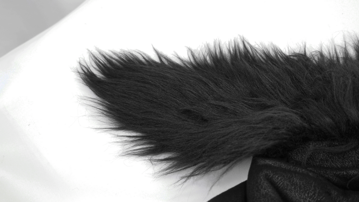 Close-up of soft black faux fur collar on a motorcycle-style jacket, adding a touch of punk elegance.