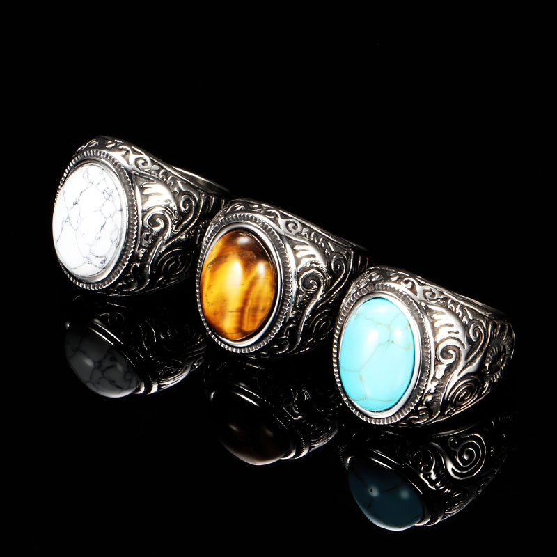 Bohemian unisex stainless steel rings with colorful stones, vintage alternative fashion jewelry on a reflective surface.