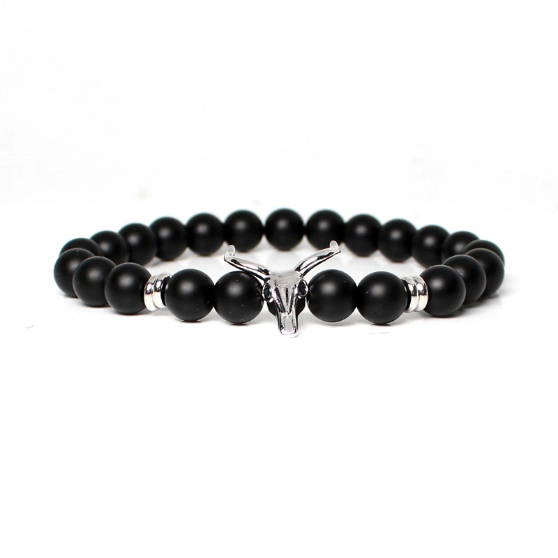 Stylish men's bracelet featuring black stone beads and a silver skull centerpiece, perfect for modern outfits.