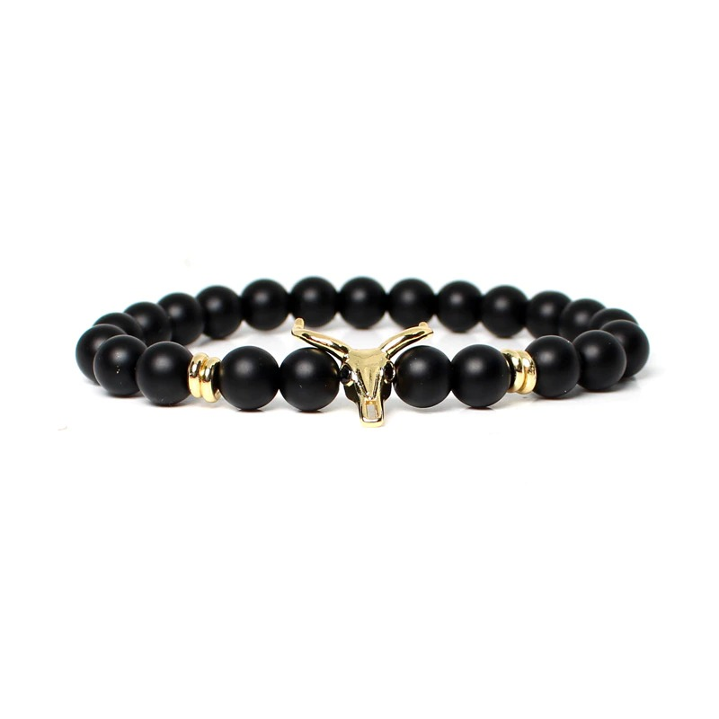 Stylish men's bracelet with black beads and a golden skull centerpiece, perfect for modern outfits.