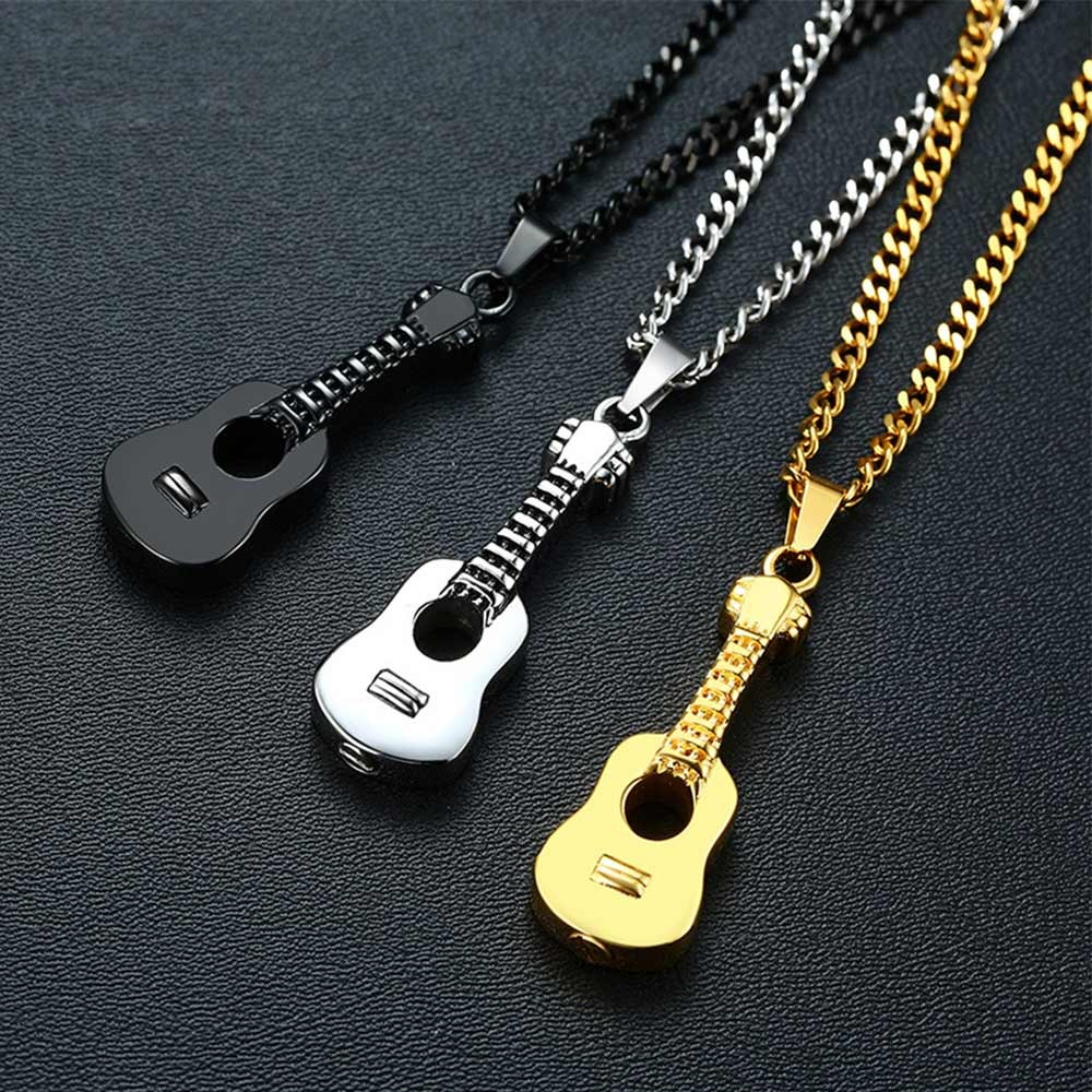 Stylish stainless steel necklaces with guitar pendants in black, silver, and gold colors on a dark background.