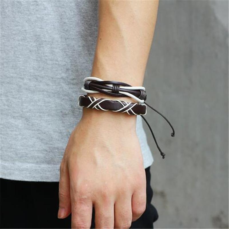 Stylish brown and white leather bracelets on a man's wrist, showcasing a rock-inspired vibe in a casual setting.