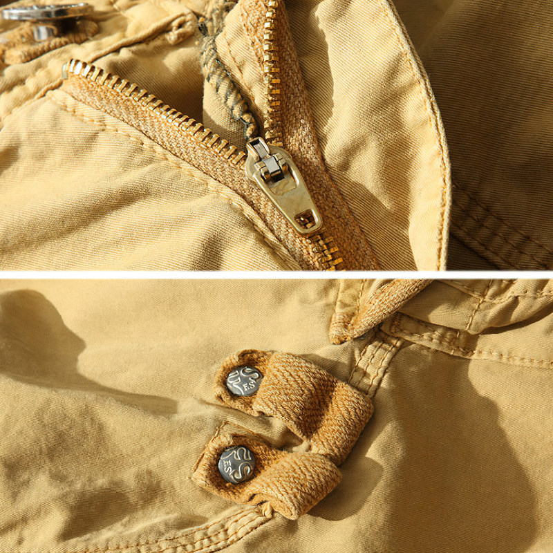 Close-up of beige cargo shorts zipper and button details for men's safari style shorts.