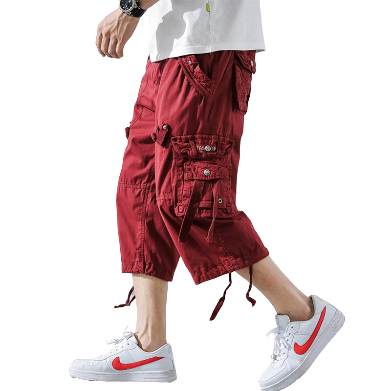 Men's red cargo shorts, stylish and comfortable for outdoor activities, paired with classic white sneakers.