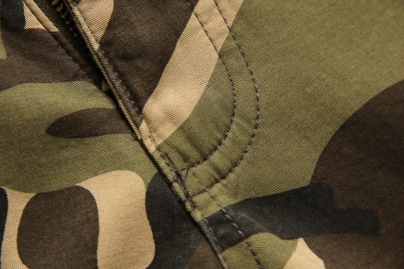 Close-up of camouflage fabric showcasing stitching details for tactical pants in green and brown colors.
