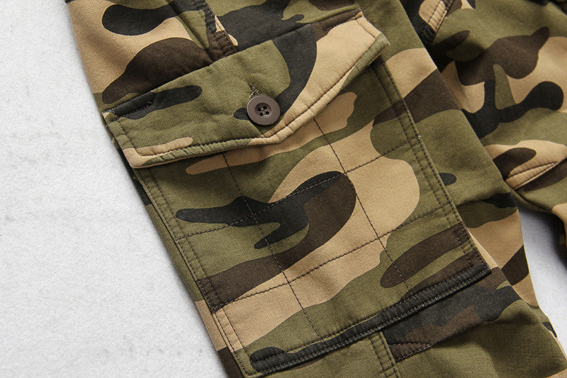 Close-up of camouflage tactical pants pocket detail, showcasing military-style fabric and button.