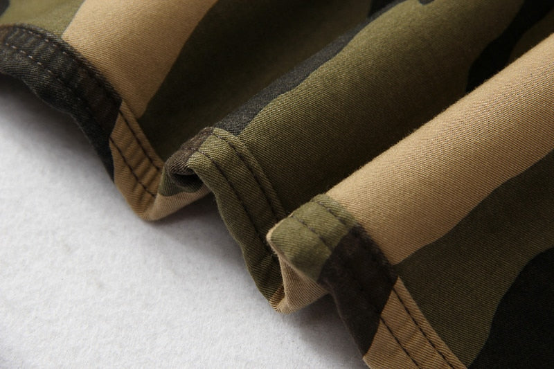 Close-up of camouflage fabric showing detailing of tactical pants in green and brown shades.