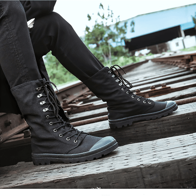 Stylish canvas lace-up mid-calf boots on a rustic train track, ideal for casual wear and tactical adventures.