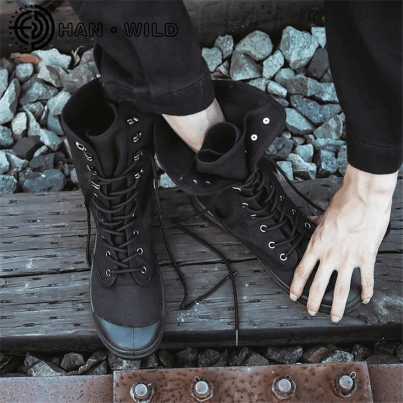 Men's black canvas lace-up mid-calf boots on wooden surface, showcasing stylish design and comfort for casual wear.