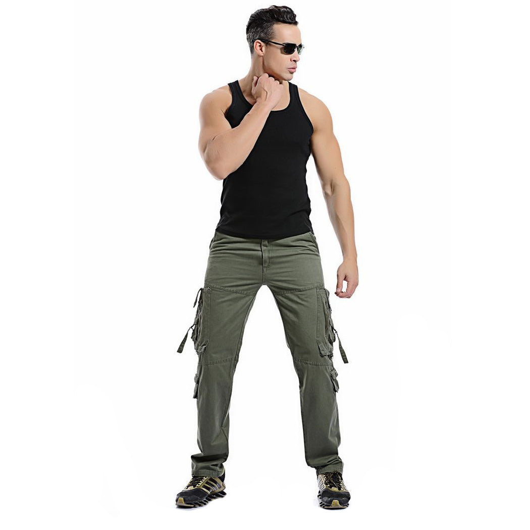 Stylish man in army green cargo pants and black tank top, showcasing casual military fashion.