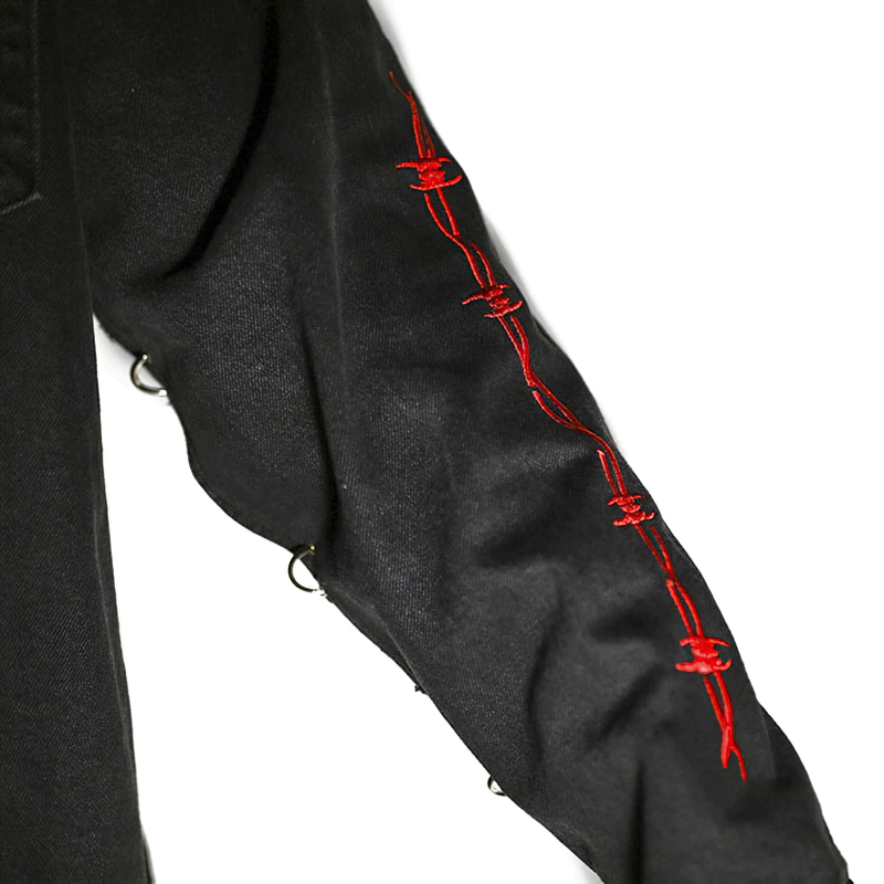 Close-up of black denim jacket sleeve with red stitched details, showcasing gothic style and alternative fashion.