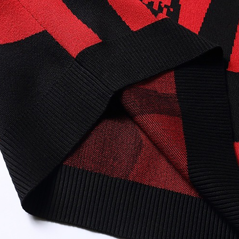 Detail of black and red casual knitting hoody with skull print and stylish ribbed hem, showcasing trendy oversized design.