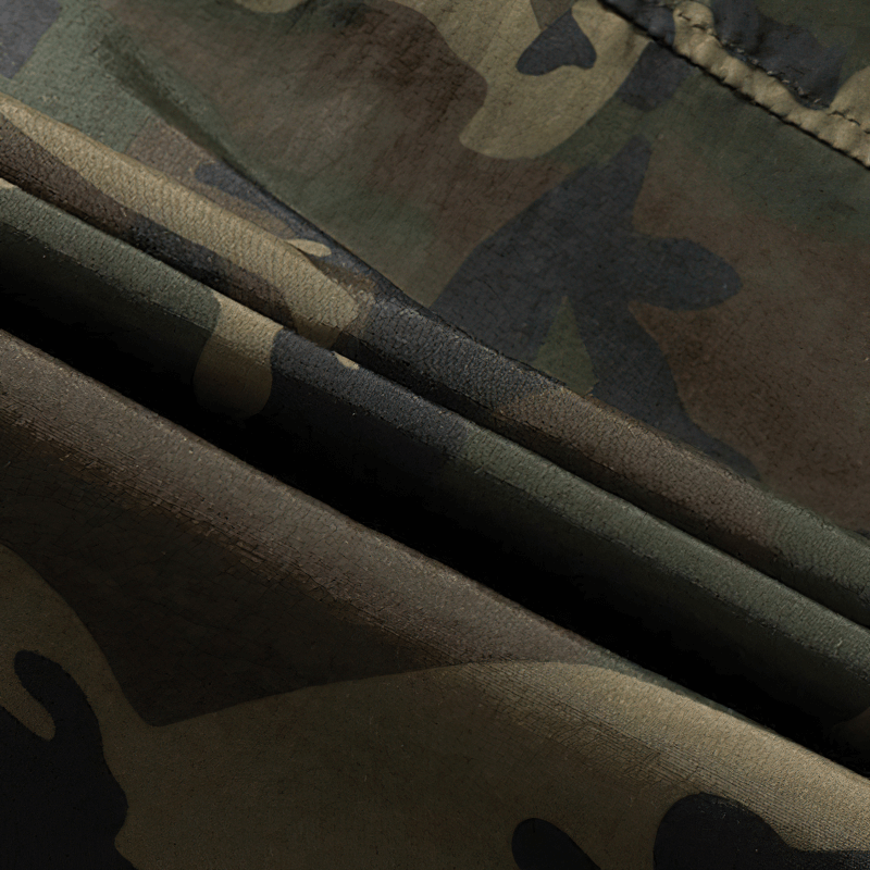 Close-up of casual loose men’s hoodie fabric featuring a stylish camouflage pattern with pockets.