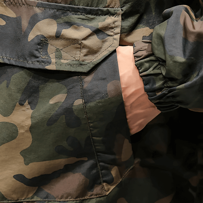 Close-up of a camo hoodie with an orange pocket detail, showcasing its stylish casual design for men.