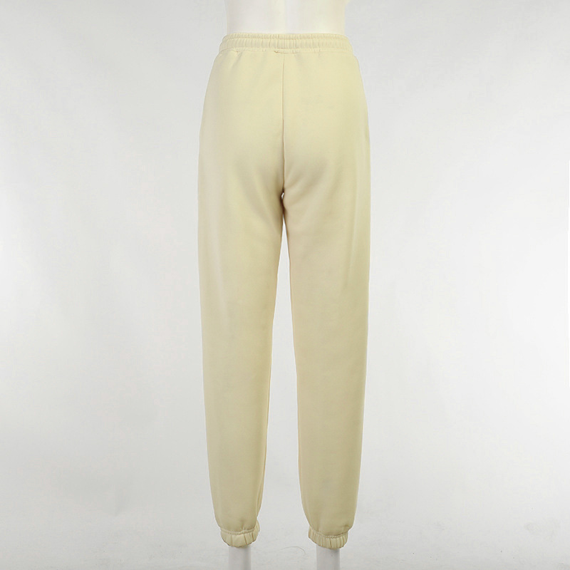 Back view of casual loose pants for women in soft cream color, featuring an elastic waistband and tapered cuffs.