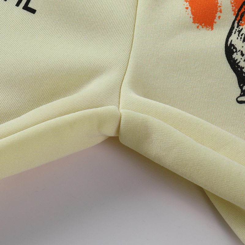 Detail shot of casual loose pants for women, featuring creative graffiti design in light yellow fabric.