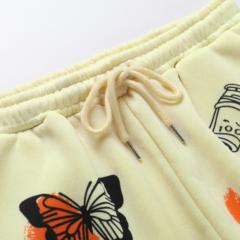 Close-up of casual loose women's pants with butterfly print and adjustable drawstring in soft fleece fabric.