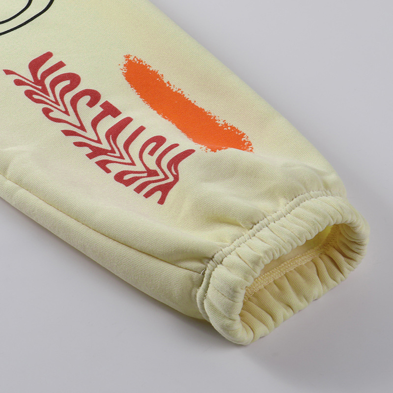 Close-up of casual loose pants for women with graffiti design and elastic cuff detail.