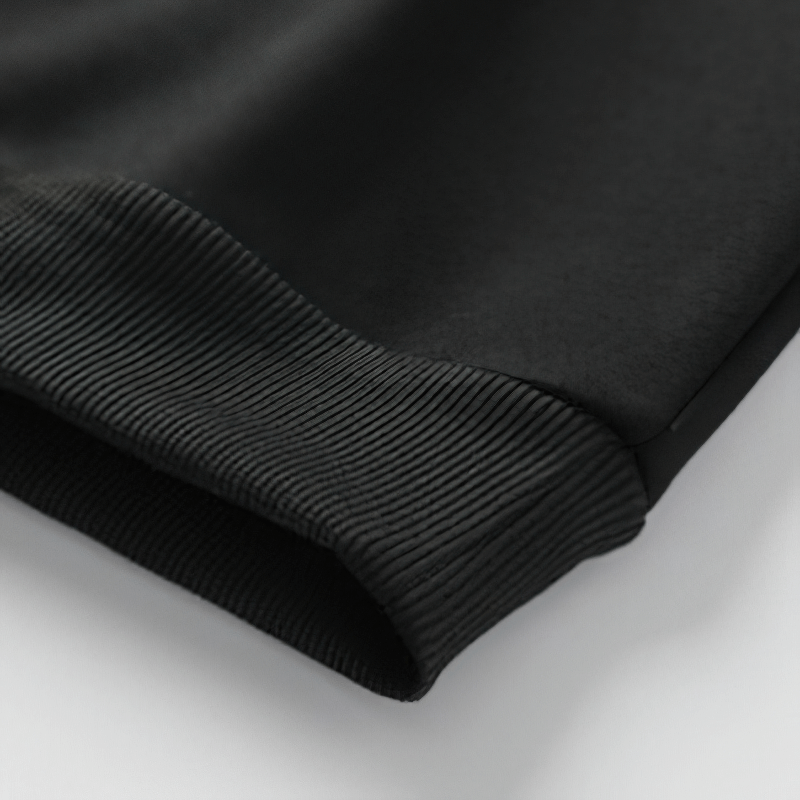Close-up view of the ribbed cuff of a black casual men's sweatshirt, showcasing its soft texture and quality craftsmanship.