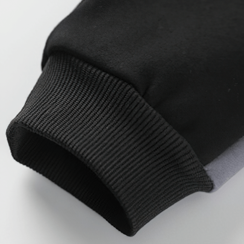 Close-up of a black cuff on a men's patchwork sweatshirt, showcasing its soft fabric and stylish design.