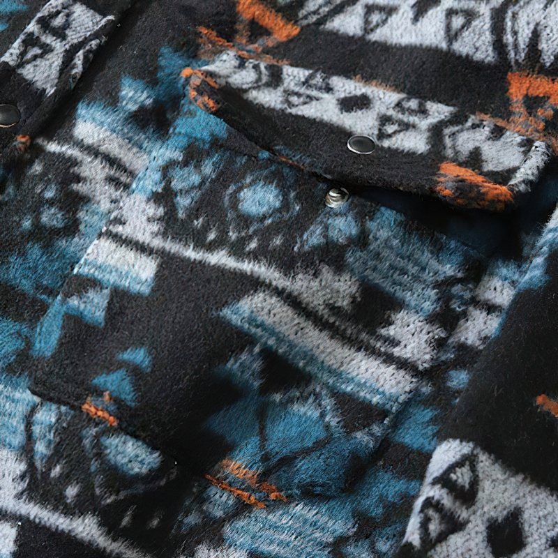 Close-up of a retro men's casual shirt featuring a geometric graphic print in black, blue, and orange.