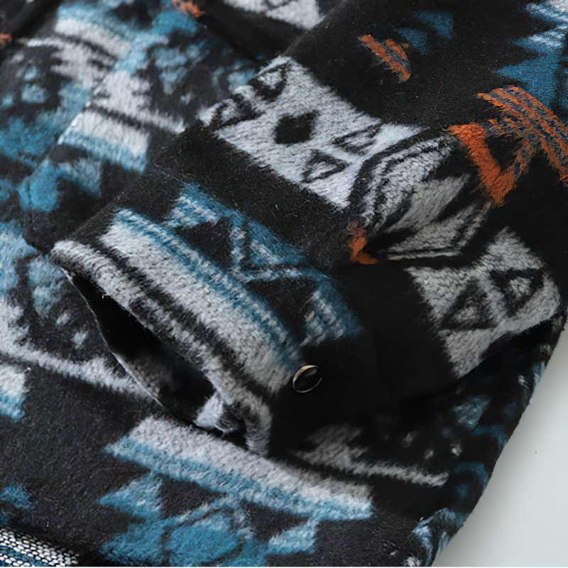 Close-up of casual men's geometric graphic shirt sleeve showcasing vibrant retro print in black, blue, and orange.