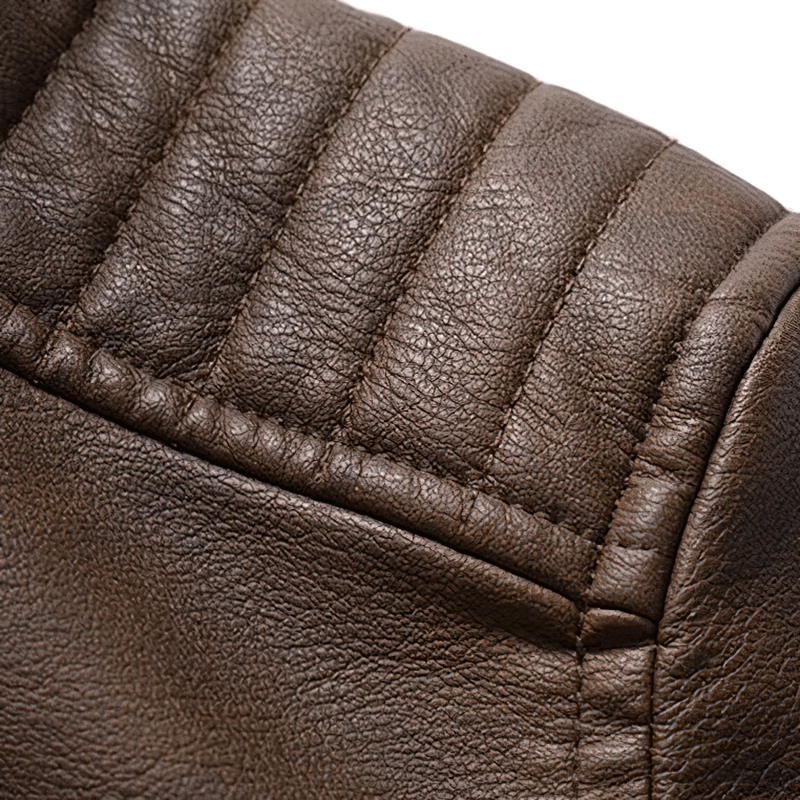 Close-up of brown faux leather texture with quilted detailing on motorcycle hooded jacket for men.