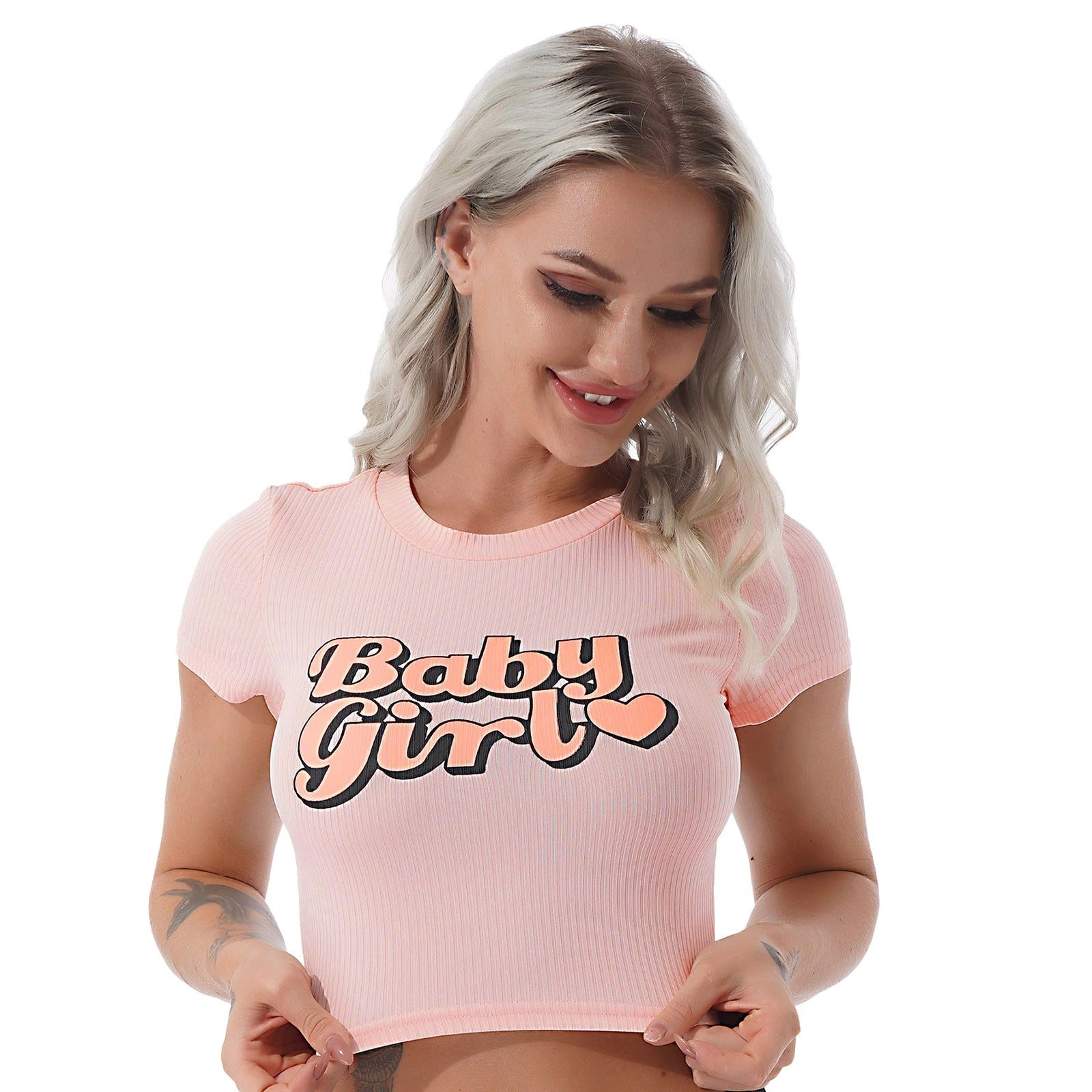 Model wearing a trendy pink crop top with 'Baby Girl' print, perfect for summer streetwear fashion.
