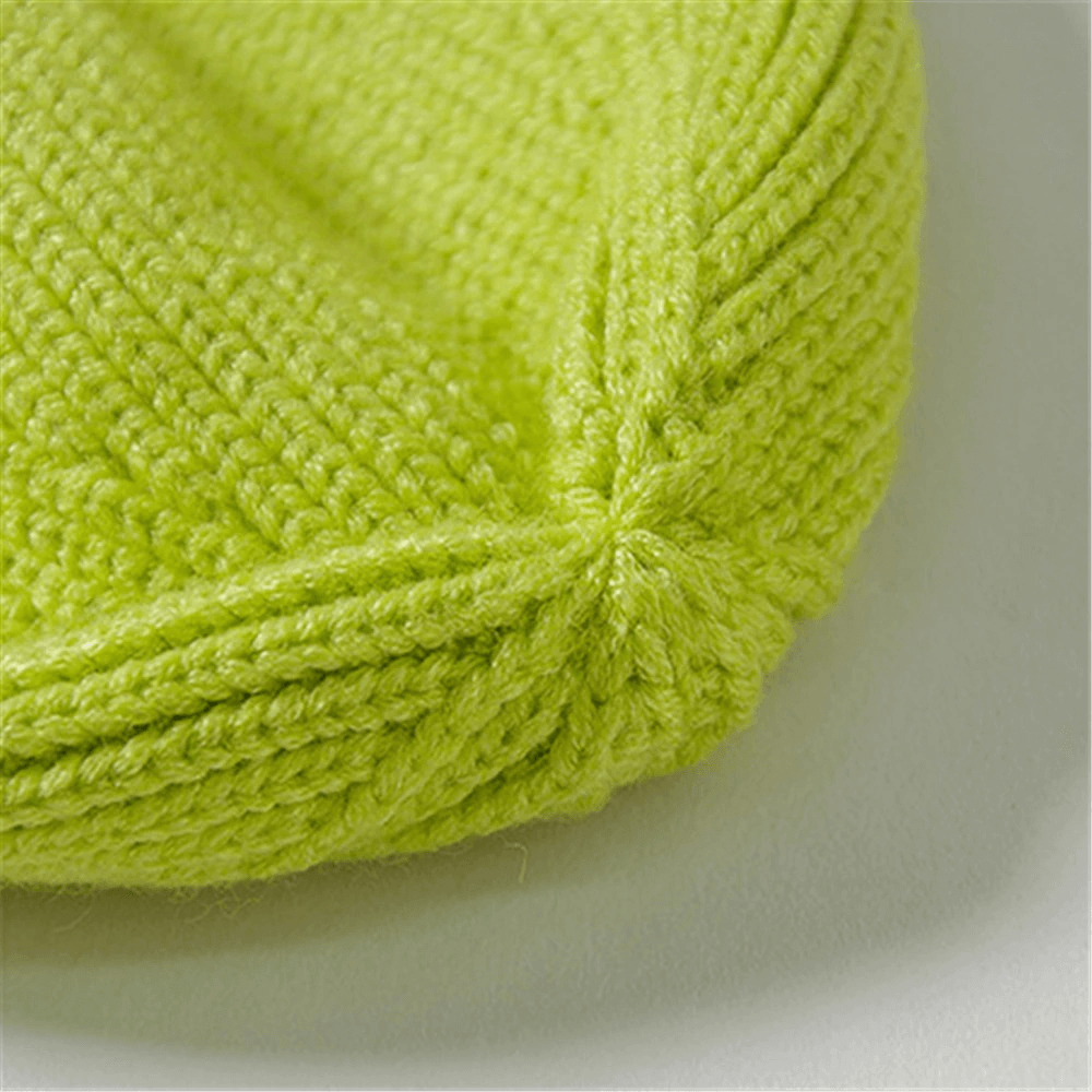 Close-up of vibrant green knitted hat showcasing cozy texture and craftsmanship.