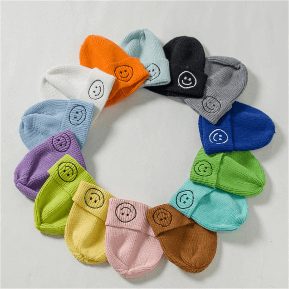 Colorful unisex knitted hats with smiley face patches arranged in a circle, perfect for casual winter fashion.