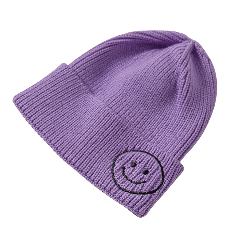 Purple knitted hat with smiley face print, a unisex fashion accessory for warmth and style.