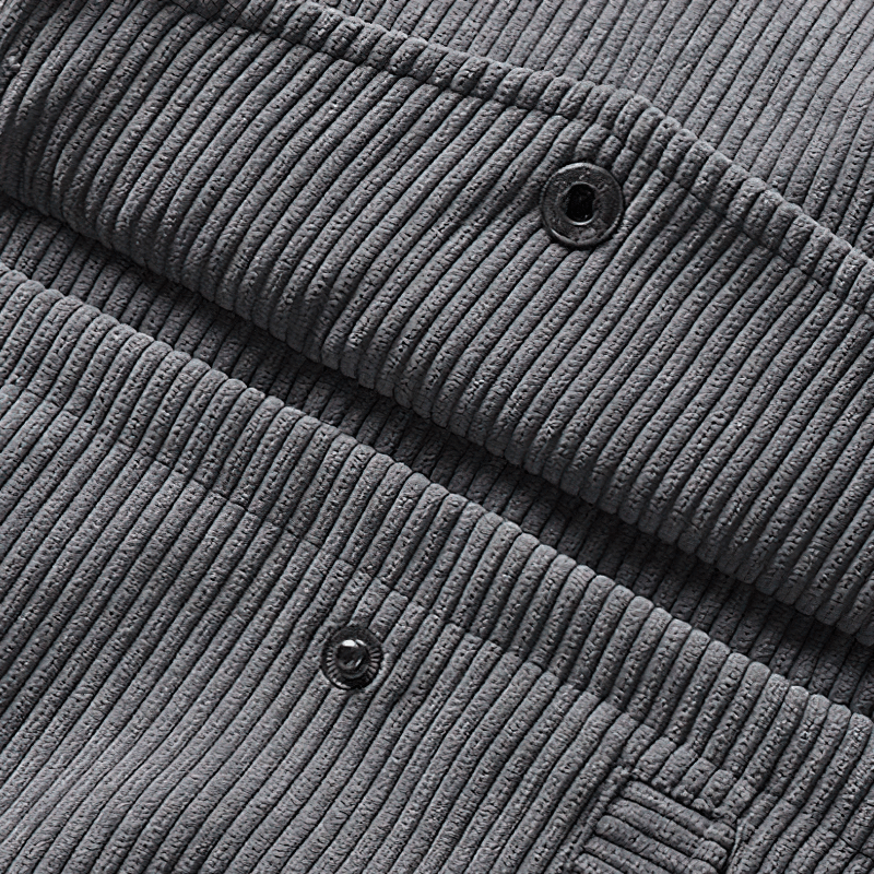 Close-up of soft gray corduroy fabric with texture and buttons, perfect for men's casual wear jackets.