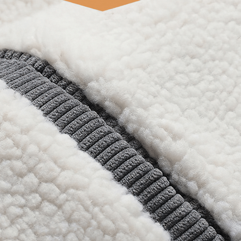 Close-up of plush white fabric with gray zipper detail, showcasing cozy texture for a stylish jacket.