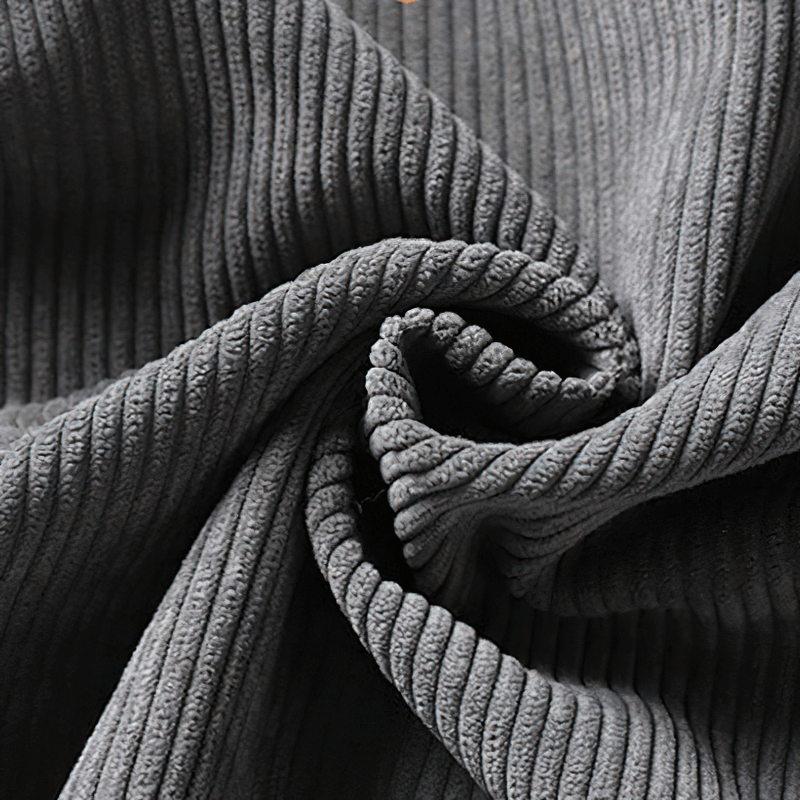 Close-up of soft grey corduroy fabric showcasing its unique ribbed texture for cozy fashion.