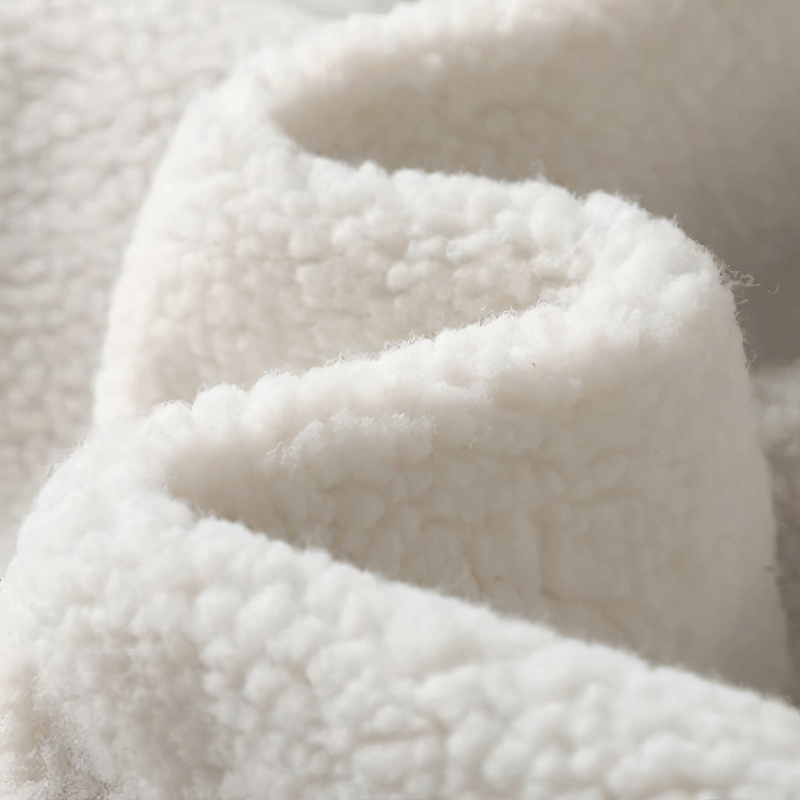 Close-up of soft, plush white fabric, showcasing a cozy texture ideal for warm clothing.